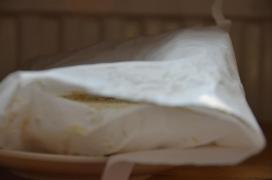 Danach wird der Laib zum Reifen gestellt - der schwierigste Teil, optimal wären wohl 13 - 15 Grad. Bei wärmeren Temperaturen fault die Mischung leicht (das hat mich einige Batches gekostet ;-)), im Kühlschrank funktioniert es, dauert aber einige Wochen. Dafür sind dort auch keine Insekten./Auch die (Luft-)feuchtigkeit ist nicht so einfach: ganz ohne wächst der Schimmel nicht (cf. Trocknen als Konservierungsmethode), wenn es zu feucht ist auch nicht, da wachsen auch eher Fäulnisbakterien und angeflogene Sporen. Daher lasse ich das Papier anfangs offen und schlage es nach ein paar Tagen unter, wenn die Oberfläche trocken ist; wenn der Käse zu trocken wird, kommt Plastikfolie oder ein Sackerl drumherum./===/Afterwards the cheese loaf gets to ferment with the fungus - the most difficult part both with regards temperature, humidity, and also hygiene./From what I gather ideal fermentation temperature would be around 13 ° C. However, if the environment is too warm, putrefactive (foul) bacteria will take over, I lost a few batches that way. The fridge is a bit too cool so it takes a few weeks, but at least there are no insects./Humidty is also critical: too little and the fungus won't grow at all, too much and other microorganisms will dominate. Therefore I usually let the loaf sit in the fridge half-open as in the picture until the skin is dry, then the paper is wrapped around completely. If it gets too dry plastic wrap or a baggie is used. Danach wird der Laib zum Reifen gestellt - der schwierigste Teil, optimal wären wohl 13 - 15 Grad. Bei wärmeren Temperaturen fault die Mischung leicht (das hat mich einige Batches gekostet ;-)), im Kühlschrank funktioniert es, dauert aber einige Wochen. Dafür sind dort auch keine Insekten./Auch die (Luft-)feuchtigkeit ist nicht so einfach: ganz ohne wächst der Schimmel nicht (cf. Trocknen als Konservierungsmethode), wenn es zu feucht ist auch nicht, da wachsen auch eher Fäulnisbakterien und angeflogene Sporen. Daher lasse ich das Papier anfangs offen und schlage es nach ein paar Tagen unter, wenn die Oberfläche trocken ist; wenn der Käse zu trocken wird, kommt Plastikfolie oder ein Sackerl drumherum./===/Afterwards the cheese loaf gets to ferment with the fungus - the most difficult part both with regards temperature, humidity, and also hygiene./From what I gather ideal fermentation temperature would be around 13 ° C. However, if the environment is too warm, putrefactive (foul) bacteria will take over, I lost a few batches that way. The fridge is a bit too cool so it takes a few weeks, but at least there are no insects./Humidty is also critical: too little and the fungus won't grow at all, too much and other microorganisms will dominate. Therefore I usually let the loaf sit in the fridge half-open as in the picture until the skin is dry, then the paper is wrapped around completely. If it gets too dry plastic wrap or a baggie is used.