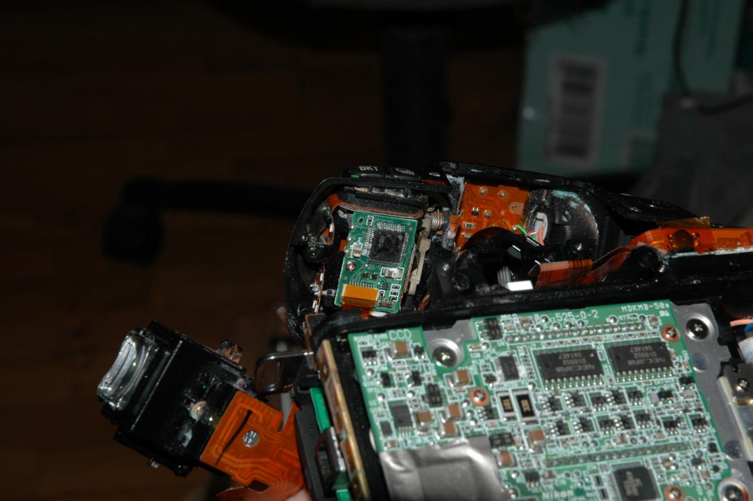 (probably) Hitachi H8/300 compatible CPU: Nikon DSB01/on the left, above the ocular (metering chip): /Sony/415PO/ILX141N/all the connections from the top LCD and the matrix metering chip seem to go to the IC on top of the camera (top of the image) (probably) Hitachi H8/300 compatible CPU: Nikon DSB01/on the left, above the ocular (metering chip): /Sony/415PO/ILX141N/all the connections from the top LCD and the matrix metering chip seem to go to the IC on top of the camera (top of the image)
